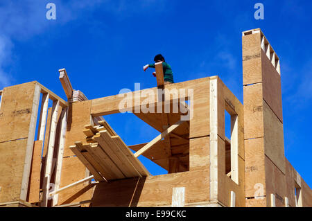 Man working on new wood frame house being constructed in, Vancouver, BC, Canada Stock Photo