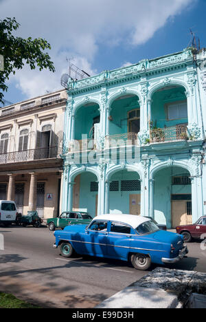 A vintage American automobile passes one of the many Spanish Colonial inspired buildings on the Prado in downtown Havana Stock Photo