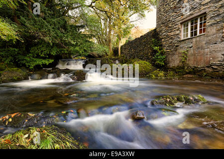 A fast flowing stream runs over rocks on it's way into Coniston lake in the Lake District, Cumbria, UK Stock Photo