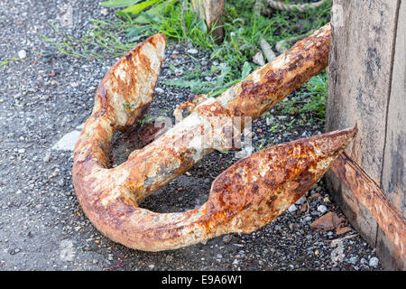 Old rusty anchor on dockside Stock Photo