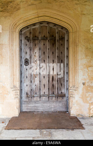 An old wooden door with stone surround in the wall of a church in ...