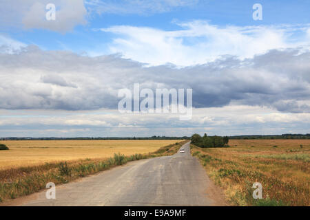 Storm clouds over the road in the steppe. Stock Photo