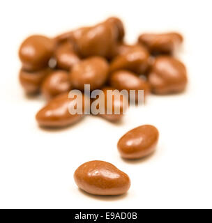 Pile of chocolate raisins on white Stock Photo
