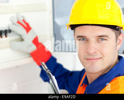 Smiling electrician repairing a power plan Stock Photo