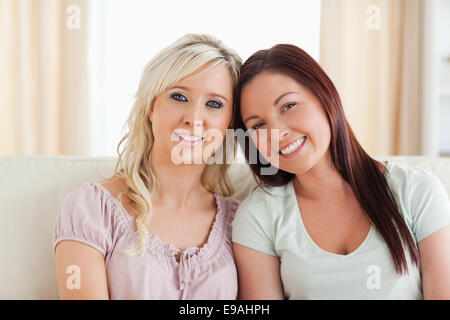 Joyful women lounging on a sofa Stock Photo