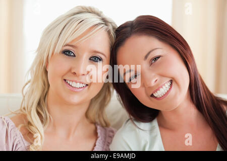 Happy women lounging on a sofa Stock Photo