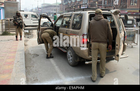 Srinagar, Indian Administered Kashmir. 23rd October, 2014. An Indian policeman checks passengers vehicles   during a one day strike  as Shops and businesses remained closed in Kashmir due to a separatist sponsored strike to protest a visit to the region by Prime Minister Narendra Modi  Credit:  Sofi Suhail/Alamy Live News Stock Photo