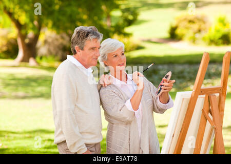 Retired couple painting in the park Stock Photo