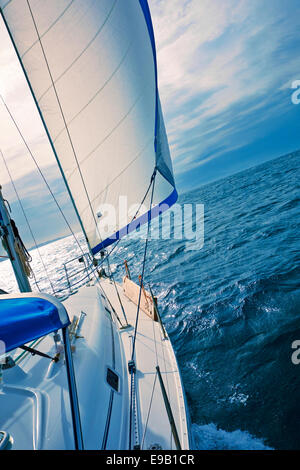 A yacht sailing downwind with a full genoa. Stock Photo