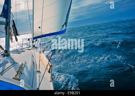 A yacht sailing downwind with a full genoa. Stock Photo