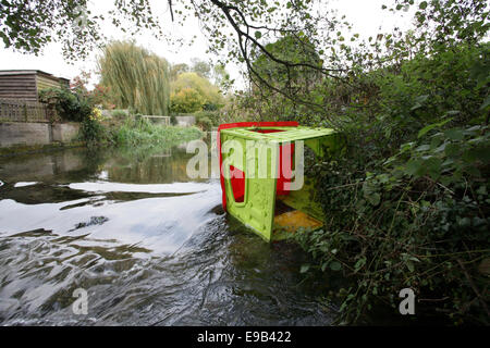 A child's Wendy house that has been thrown in to a river in the Wiltshire Countryside UK. Stock Photo