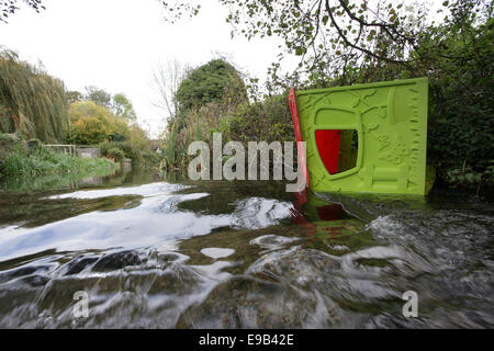A child's Wendy house that has been thrown in to a river in the Wiltshire Countryside UK. Stock Photo