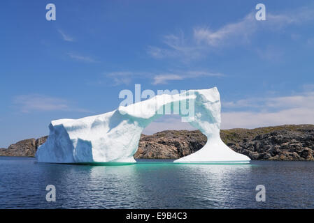 Iceberg in front of a rocky island near Twillinggate, Newfoundland and Labrador, Canada Stock Photo