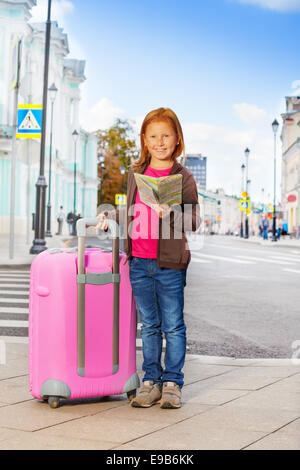 Smiling girl alone on the street with city map Stock Photo