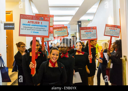 Paris, France. Trade Show, 15th Congress of SFLS, French Society in FIght against AIDS, N.G.O's, and Drug Companies. Women Holding Signs for Meetings announcement in Hall Stock Photo