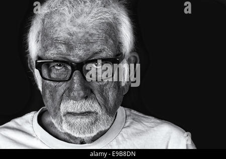 Black and white portrait of an elderly sad man with a tear rolling down his cheek Stock Photo