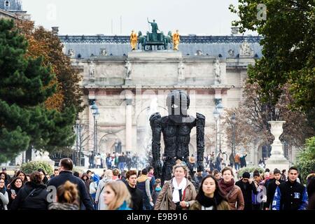 Paris, France. 23rd Oct, 2014. People pass by a piece of art entitled 'Giant Figure (Cyclops)' by Thomas Houseago which is displayed at the 'outside the walls' exhibition of the 41st International Contemporary Art Fair (FIAC) in the Tuilleries Garden in Paris, France, Oct. 23, 2014. The FIAC runs from Oct. 23 to Oct. 26. Credit:  Etiene Laurent/Xinhua/Alamy Live News Stock Photo