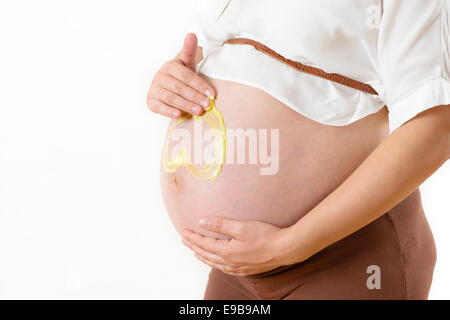 Pregnant Woman Applying Moisturizer on belly Stock Photo