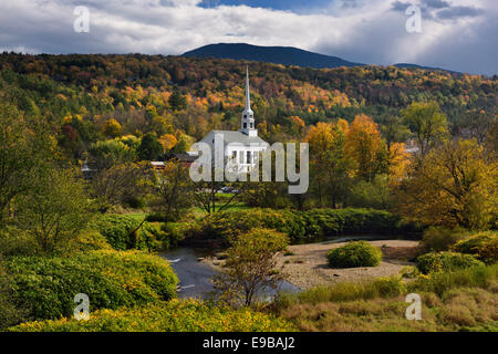 Waterbury river with Stowe Community Church against Fall color on Brush Hill in Vermont USA Stock Photo