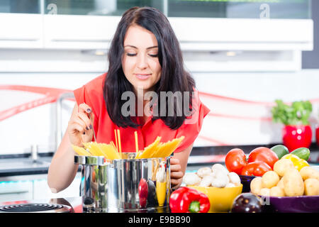 Woman cooking pasta in domestic kitchen Stock Photo