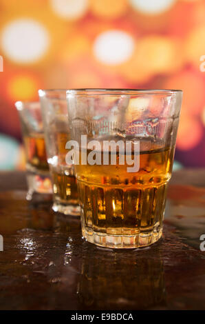 shots of rum whiskey over defocused lights background Stock Photo