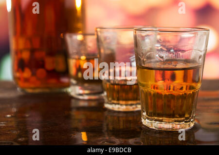 shots of rum whiskey over defocused lights background Stock Photo