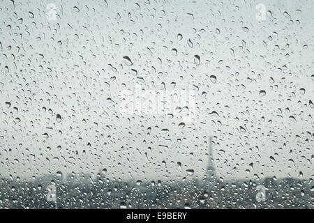 Rain drops in focus and skyline of Paris, including Eiffel Tower in background. Showery day in June. from Centre Pompidou,Paris, Stock Photo