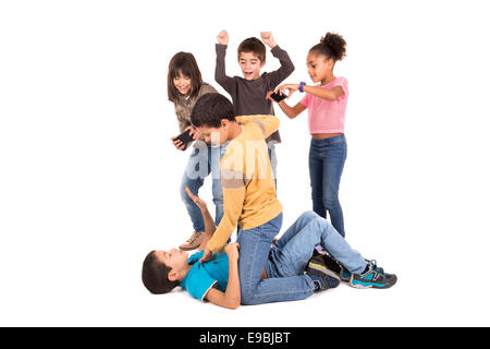 Boys fighting with other kids cheering and filming Stock Photo