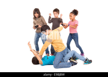 Boys fighting with other kids cheering and filming Stock Photo