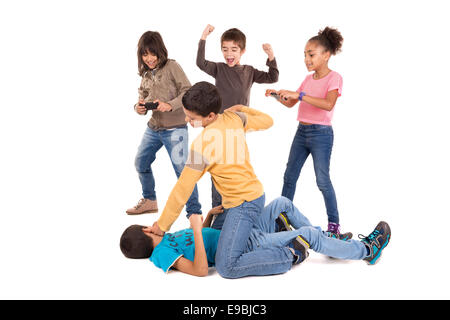 Boys fighting with other kids cheering and filming Stock Photo