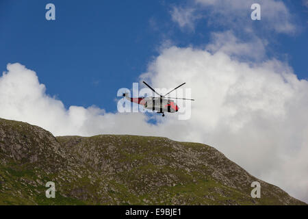 Royal Navy rescue helicopter operating above the slopes of Glen Nevis near Ben Nevis Stock Photo