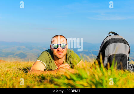 Man lying on grass at sunny day Stock Photo