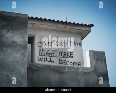 unfinished abandoned building projects in Cyprus, building site graffiti slogan one day this nightmare will become a dream Stock Photo