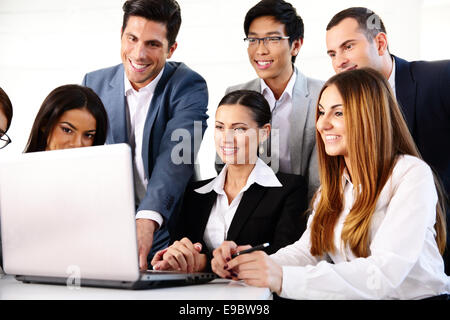 Smiling businesspeople working on the laptop together Stock Photo