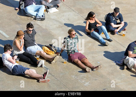 BARCELONA - MAY 30: A man from the audience watches a concert and have a beer sitting in the floor. Stock Photo