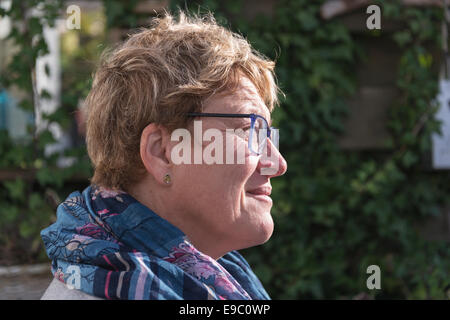 woman with golden hair and glasses thinking in the garden Stock Photo