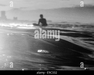 Surfer waiting for wave in ocean BW Stock Photo