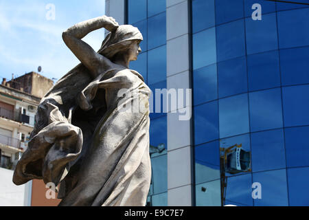 Statue of a woman inside the Recoleta monumental cemetery with a modern building in background. Buenos Aires, Argentina. Stock Photo