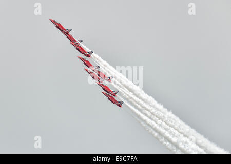 Nine Hawker Siddeley Hawk Jet Trainers of the British Royal Air Force Red Arrows Aerobatic Display Team perform the Diamond roll Stock Photo