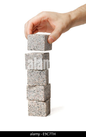 Man stacking small blocks of granite rock. Stock Photo