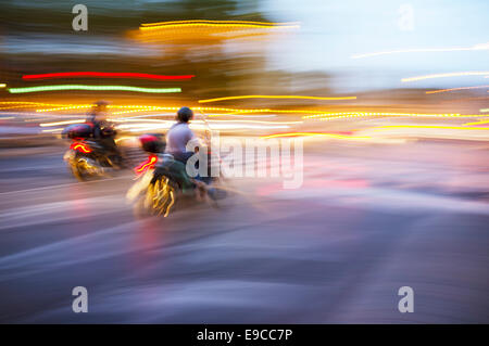 Abstract blurry image of a scooters driving at night. Stock Photo