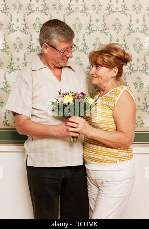 Older man giving wife bouquet of flowers Stock Photo