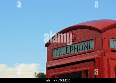 Close-up of the top of a traditional British telephone box with blue sky background Stock Photo