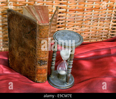 Vintage book and hourglass on old table closeup image Stock Photo