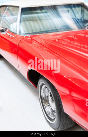 Close Up Detail of Shiny Red Classic Car in Studio with Focus on Wheel, Hood, and Windshield. Stock Photo