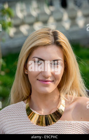 Blonde woman with gold necklace smiling Stock Photo