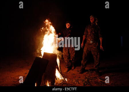Fighters of the Kurdish People's Protection Unit YPG fighter setting up a bonfire in a military compound in Al Hasakah or Hassakeh district in Rojava the de facto Kurdish autonomous region originating in and consisting of three self-governing cantons in northern Syria Stock Photo