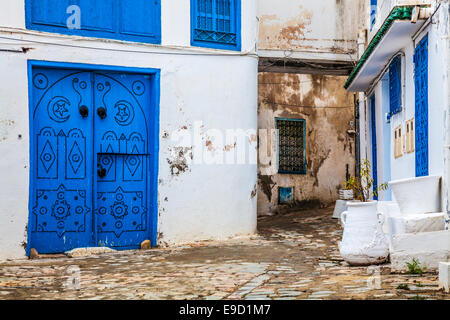 A typical blue, studded wooden doorand wrought iron window guards in Sidi Bou Said, Tunisia. Stock Photo