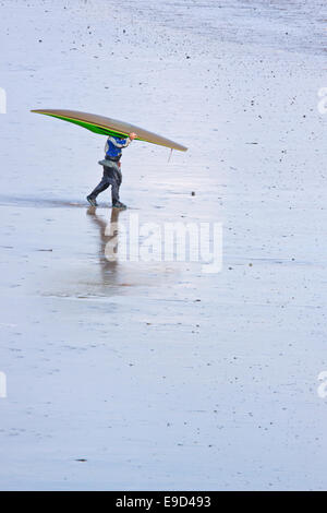 Lone body boarder on a popular North Devon beach returning to the shore Stock Photo