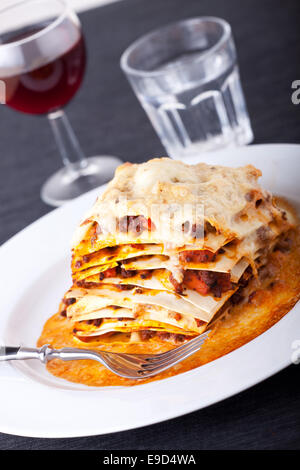 closeup of lasagna with red wine Stock Photo